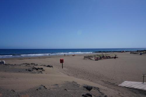 a beach with a group of people and the ocean at Vv - San Agustín Seaview Apartment in San Agustin