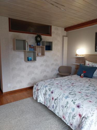 a bedroom with a bed with a floral bedspread at Chez Pascale & Pierre in Kogenheim