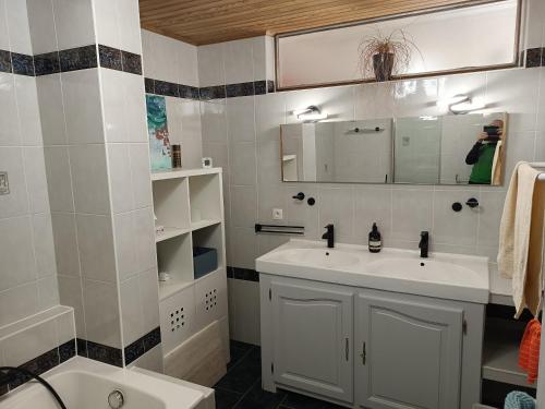 a white bathroom with a sink and a mirror at Chez Pascale & Pierre in Kogenheim