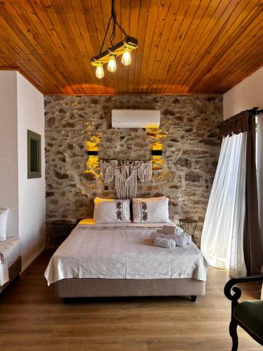 a bedroom with a bed and a stone wall at Chori Avlu Küçükköy in Ayvalık