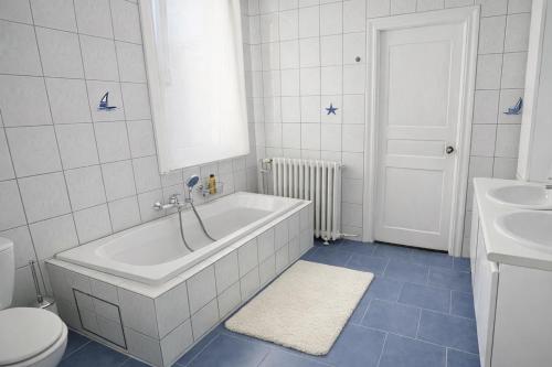 a bathroom with a tub and a toilet and a sink at Loft Chaleureux - Le Chalet Montois in Mons