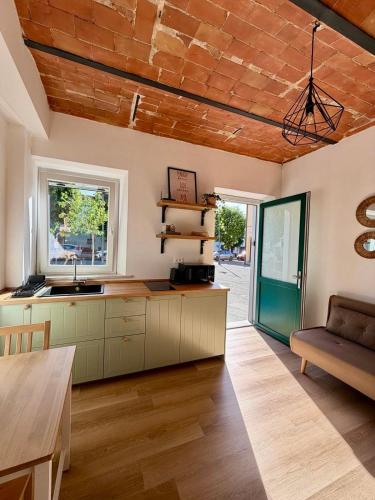 a kitchen with a wooden ceiling and a table at Casetta di Dodo - Charm Toscano in Centro in Collesalvetti