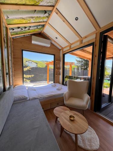 a bedroom in a tiny house with a bed and a chair at Sarajevo jacuzzi sauna Forest romance lodge in Sarajevo