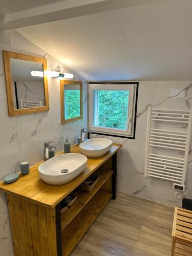 a bathroom with two sinks and a mirror at Relais Venise verte in Coulon