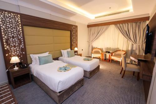 a hotel room with two beds and a table at Diamond Vision Hotel in Jeddah