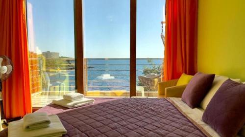 a bedroom with a bed with a view of the ocean at Vila Nadja SEAFRONT in Bar