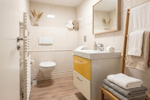 a bathroom with a sink and a toilet at Strandnest VILLA KAETHE am Kurpark - gemütliche 60qm Ferienwohnung für Zwei in Warnemünde