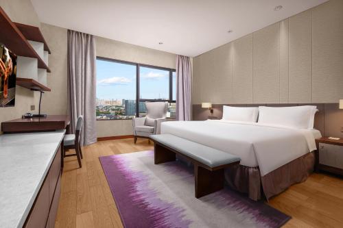 a bedroom with a large bed and a large window at Ascott Raffles City Chengdu in Chengdu