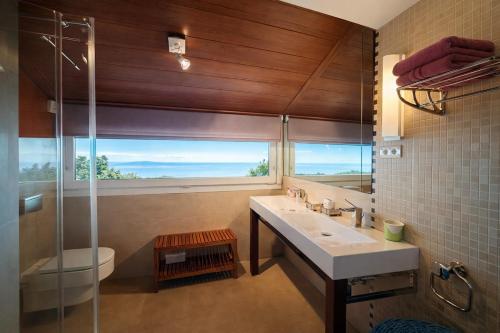 a bathroom with a sink and a shower with a window at Winahost Casa Nívar in Nívar