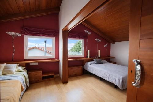 a bedroom with two beds and two windows at Winahost Casa Nívar in Nívar