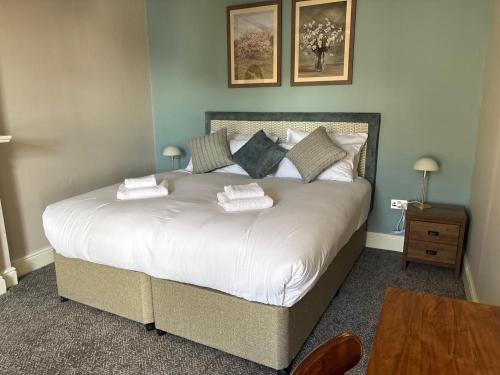 a bedroom with a large bed with two towels on it at Oak House Hotel in Axbridge
