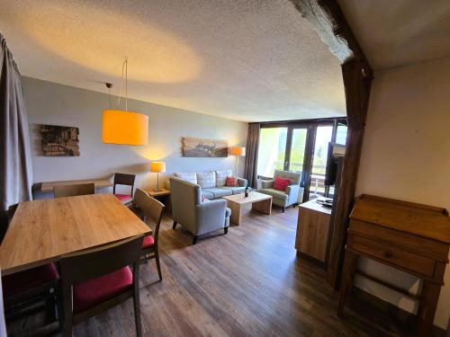 a living room with a couch and a dining room at Beatenberg Alpine Residence in Beatenberg