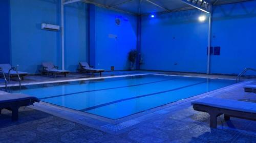 a swimming pool at night with blue lights at Hmaasat Intour Hotel فندق همسات انتور in Jazan