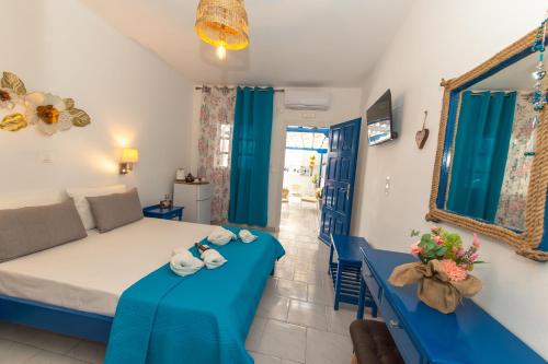 a living room with a bed and a blue table at Lunar Seaside Hotel in Perissa