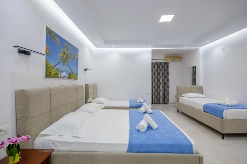 a bedroom with two beds and a couch at Ksamil Guesthouse Villa in Ksamil