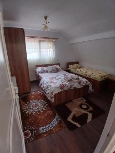 a small bedroom with two beds and a window at Cabana La Marian in Munună