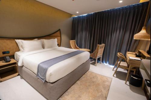 a hotel room with a large bed and a desk and a desk at Pixcel Holidays in Calangute