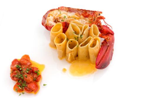 a plate of food with pasta and a hot dog at Hotel Weber Ambassador in Capri