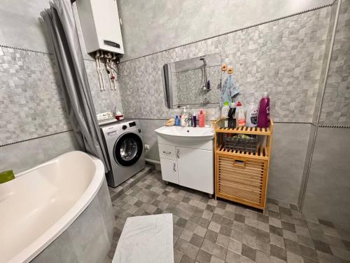 a bathroom with a sink and a washing machine at Zarisha Home in Fergana