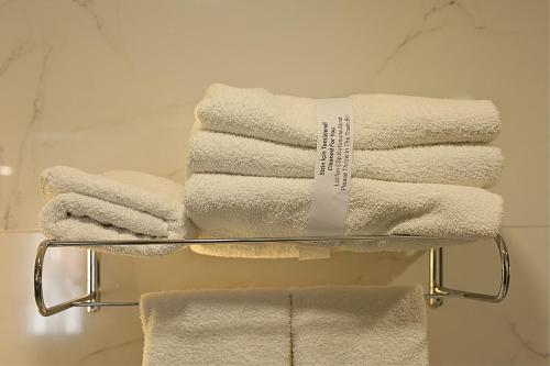 a stack of towels on a towel rack in a bathroom at Ren Business Hotel in Gerede
