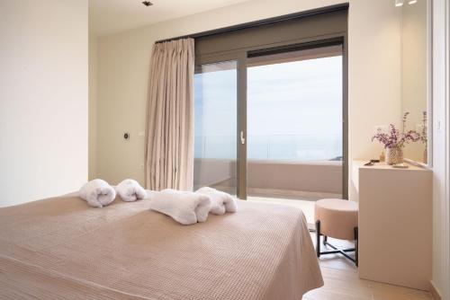 a bedroom with a bed with towels on it at Lina's Luxury Villas in Skala