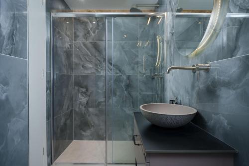 a bathroom with a sink and a glass shower at Lina's Luxury Villas in Skala