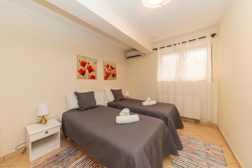 a bedroom with two beds and a window at Villa Zubčić in Zadar