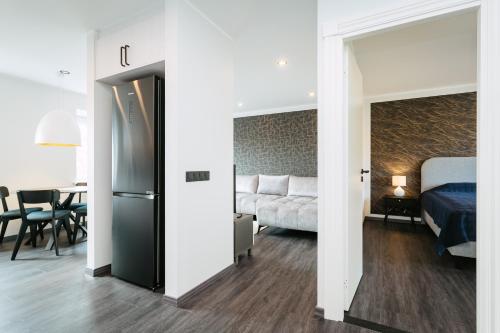 a bedroom with a bed and a room with a refrigerator at Sea view apartment Haapsalu in Haapsalu