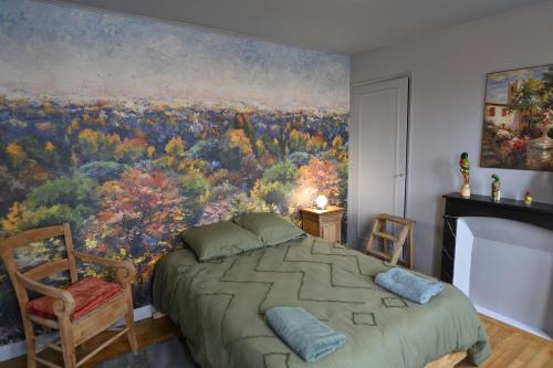 a bedroom with a large painting on the wall at gîte MAELYSE in La Neuve-Lyre