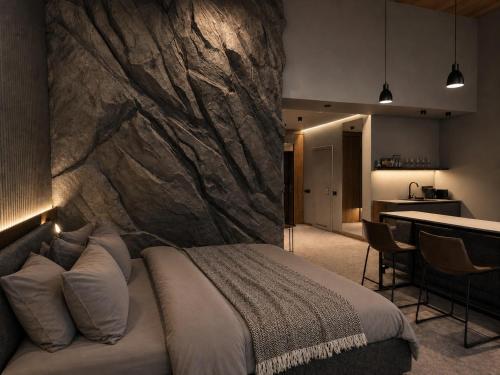 a bedroom with a large stone wall behind a bed at Wood Hotel Resort & SPA in Bukovel