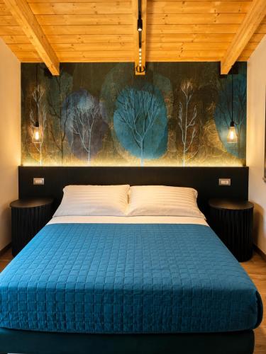 a bedroom with a bed with a blue comforter at Lumamè Resort B&B in Montefiore Conca