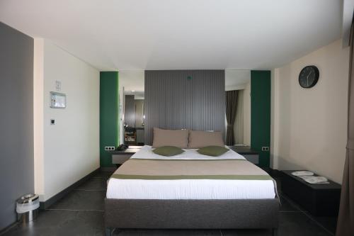 a bedroom with a large bed with green walls at Ren Business Hotel in Gerede