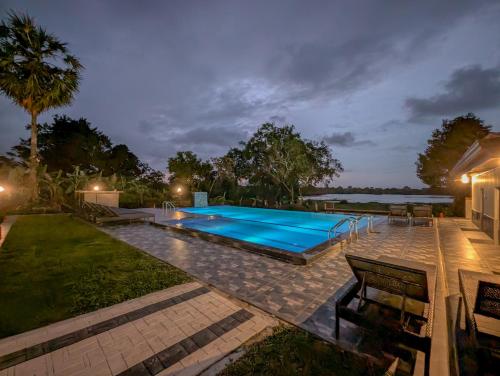 a swimming pool in a backyard at night at Choona Lodge 'view of sigiriya & pidurangala with sunrise' in Sigiriya