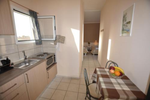 a kitchen with a table with a bowl of fruit on it at Ammos in Roda