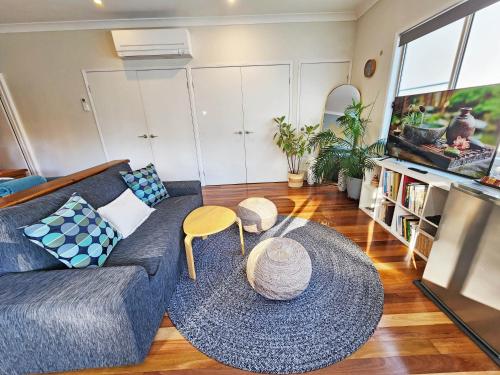 a living room with a couch and a table at Cosy Studio with Forest Views, Noosa Hinterland in Doonan