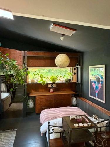 a bedroom with a bed and a table and a window at Nyúlászó Vendégház Stúdiólakás in Mád