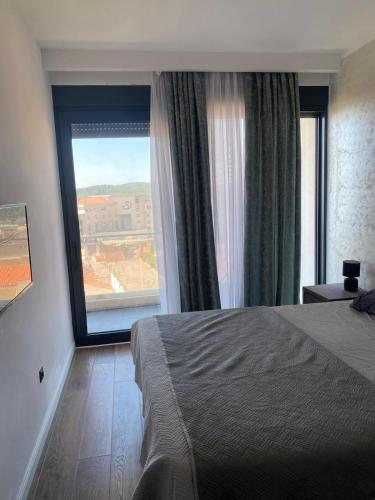 a bedroom with a bed and a large window at Elia in Bečići
