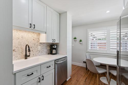 a kitchen with white cabinets and a table at Sea Renity - 4333 Twelfth Street in Saint Simons Island