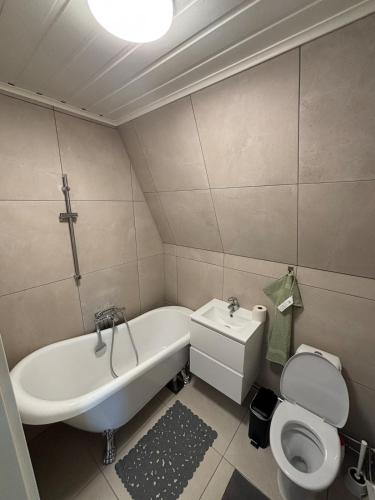 a bathroom with a tub and a toilet and a sink at High Coast Stay Floor 2 in Ramvik