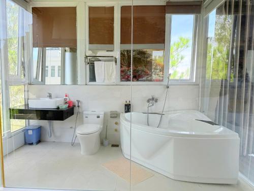 a bathroom with a tub and a toilet and a sink at Starview Villa Dalat in Da Lat