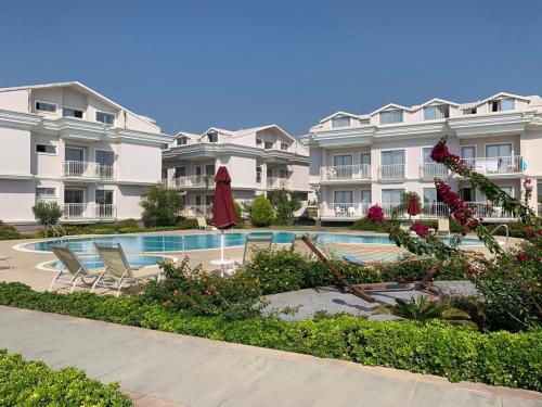 a large apartment complex with a swimming pool and chairs at Defne Beach Makri in Fethiye
