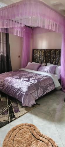 a purple bedroom with a bed with a canopy at Sylvan hotel in Kasangati