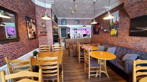 a restaurant with tables and chairs and a brick wall at Leecliff Guest House in Blackpool