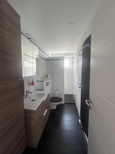 a white bathroom with a sink and a toilet at Wohnung mit Gartenblick in Hofgeismar