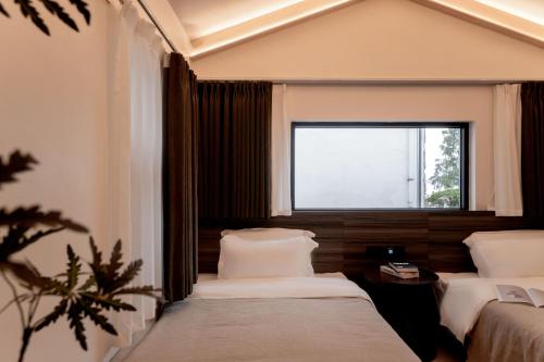 a bedroom with two beds and a window at 大理洱畔民宿 in Dali
