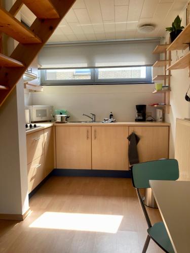 a kitchen with wooden cabinets and a sink at Aoja in Maasmechelen