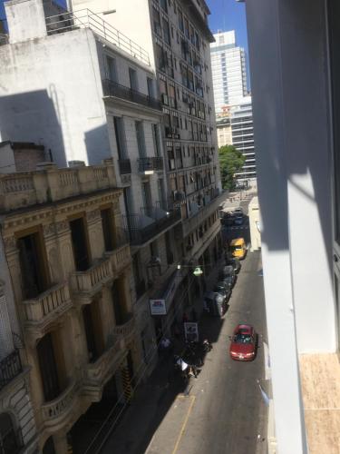 a view of a city street with a red car at Hotel El Porteño in Buenos Aires