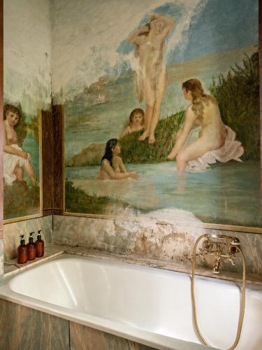 a bath tub in a bathroom with a painting at Lake House by Veneto Villa in Albignasego