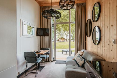 a living room with a couch and a table and chairs at Tiny House in Kesteren