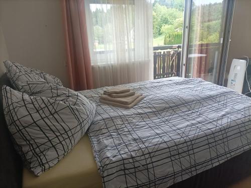 a bed with two towels on it with a window at Appartement Draublick in Unterpudlach